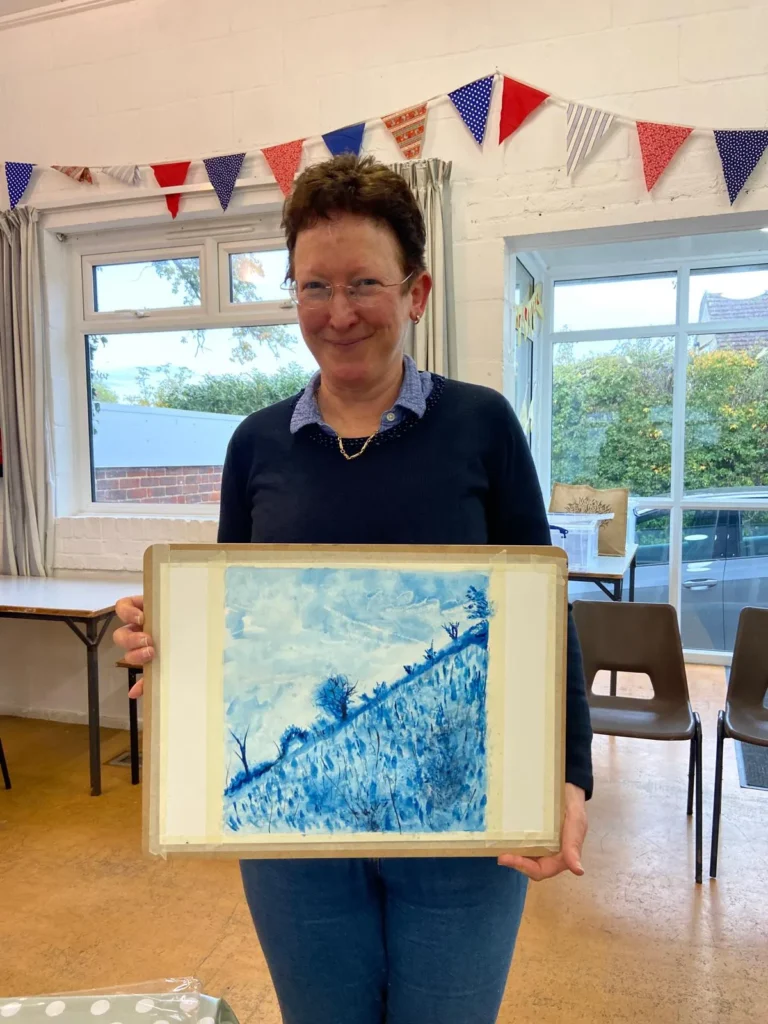 Guildford student holding up their landscape artwork