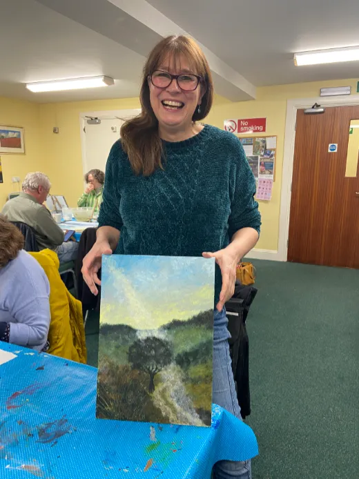 Newbury student holding up their landscape artwork